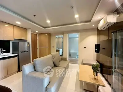 Modern living room with sleek kitchen, cozy sofa, and stylish decor in a contemporary apartment.