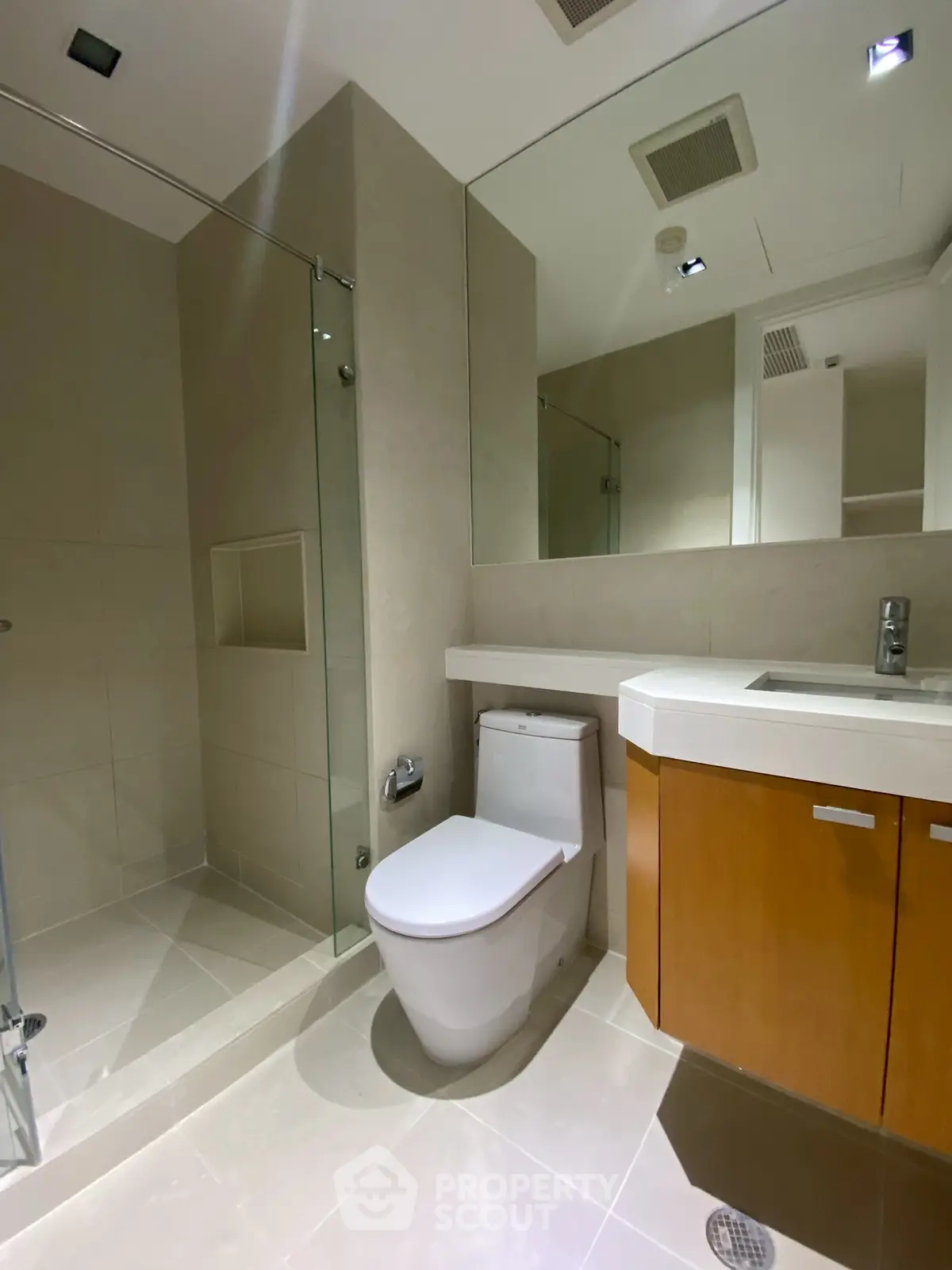 Modern bathroom with sleek design, featuring a glass-enclosed shower and contemporary fixtures.