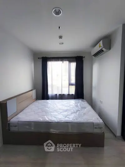 Modern bedroom with large window and air conditioning in a stylish apartment.