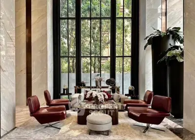 Luxurious living room with elegant seating and large windows offering a stunning garden view.