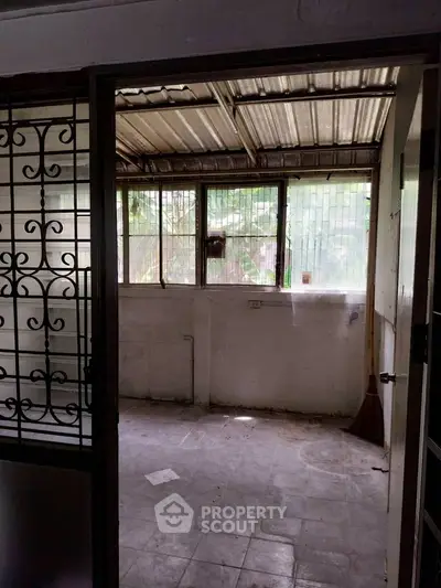 Spacious room with large windows and tiled floor, ideal for renovation or creative projects.
