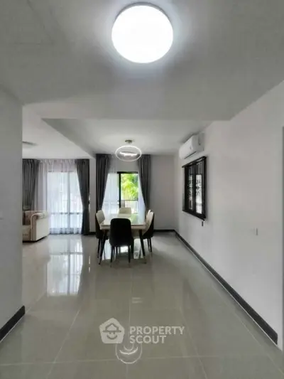 Spacious modern living and dining area with sleek tile flooring and abundant natural light.