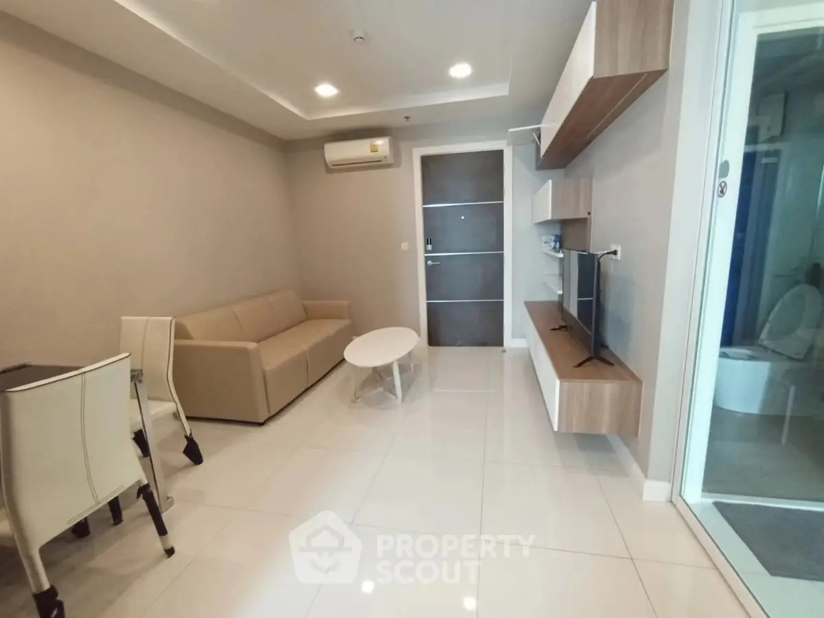 Modern living room with sleek furniture and wall-mounted TV in a stylish apartment.