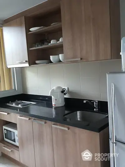 Modern kitchen with wooden cabinets and sleek black countertop