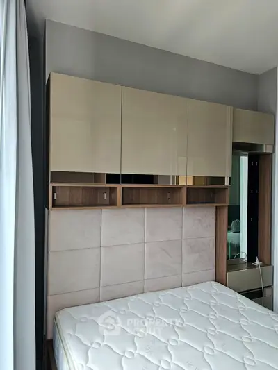 Modern bedroom with sleek storage cabinets and plush headboard
