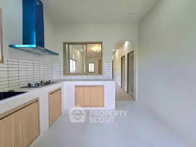 Modern kitchen with sleek design, featuring gas stove and ample natural light.