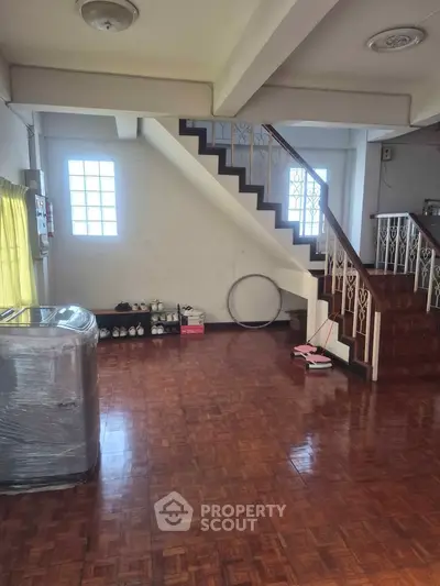 Spacious interior with wooden flooring and staircase, ideal for modern living.