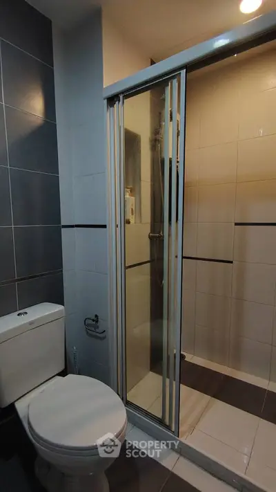 Modern bathroom with sleek shower and toilet in contemporary design.