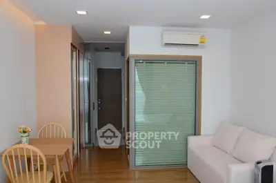 Modern living room with wooden flooring, cozy sofa, and dining area in a stylish apartment.