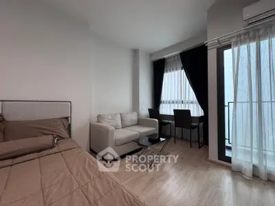 Modern studio apartment with cozy living area and balcony access
