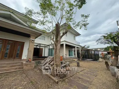 Spacious two-story house with large garden and unique architectural design.