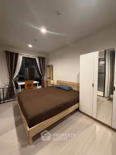 Modern bedroom with wooden furniture and large window for natural light