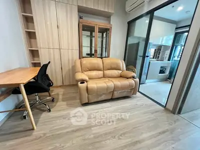 Modern living room with cozy leather sofa and study area in stylish apartment.