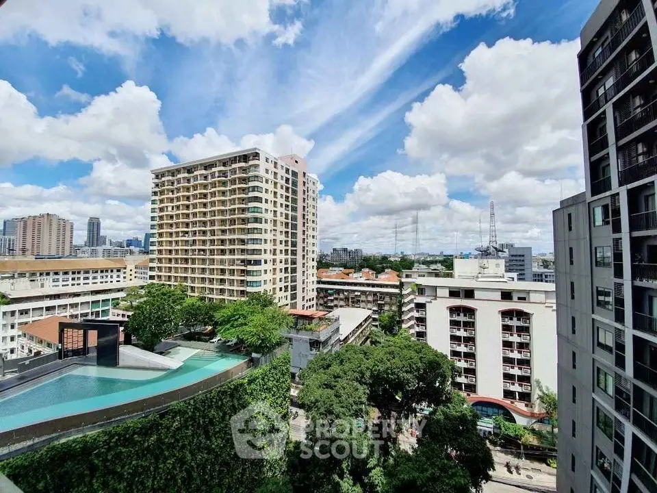 Stunning cityscape view with modern buildings and rooftop pool under a vibrant sky.