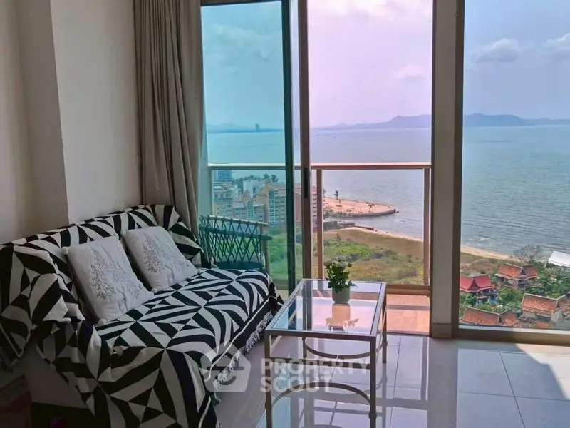 Stunning ocean view from modern living room with stylish decor and large windows.