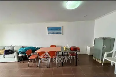 Spacious living room with dining area and modern furniture in a cozy apartment.