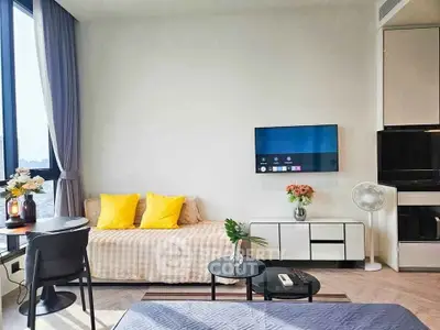 Modern living room with stylish decor, featuring a cozy sofa, wall-mounted TV, and large window with city view.