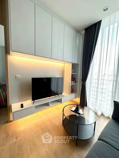 Modern living room with sleek cabinetry and large window offering city views.