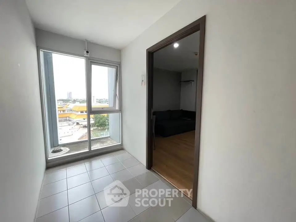 Bright apartment interior with large windows and city view, showcasing modern living space.