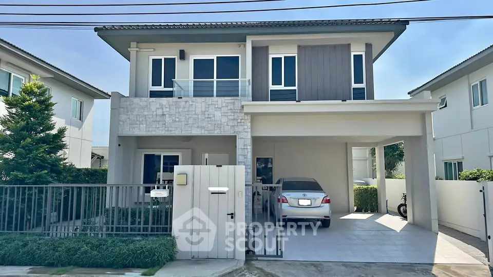 Modern two-story house with carport and stylish facade in suburban neighborhood.