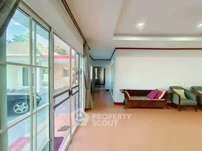 Spacious living room with large windows and cozy seating area