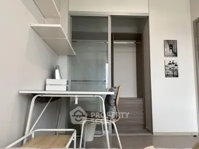 Modern study room with sleek desk, chair, and open closet in stylish apartment.