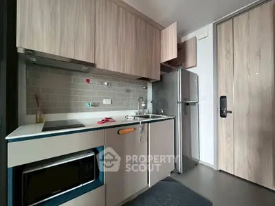 Modern kitchen with sleek cabinetry and stainless steel appliances in a contemporary apartment.
