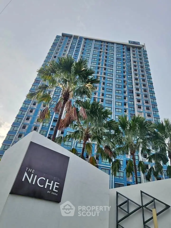 Stunning high-rise building with modern architecture and palm trees, perfect for urban living.