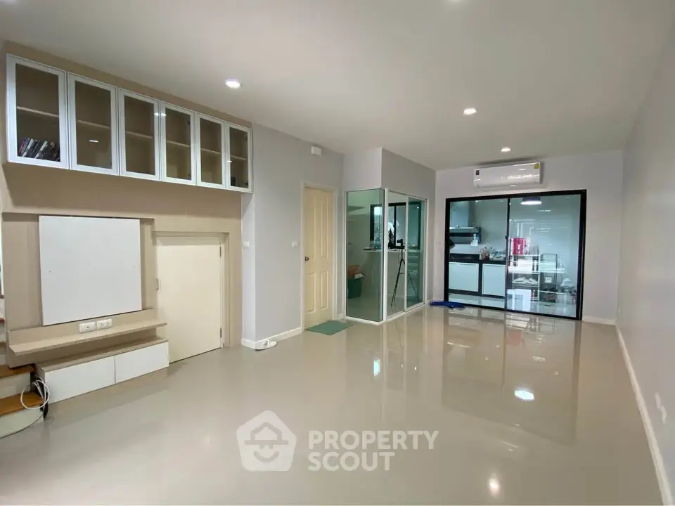 Spacious modern living room with sleek flooring and built-in storage