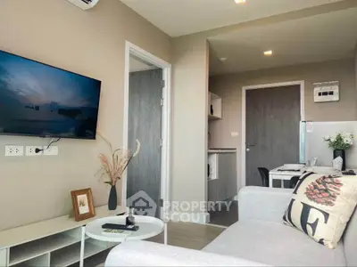 Modern living room with stylish decor and wall-mounted TV in a cozy apartment.