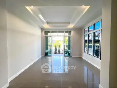 Spacious modern living room with large windows and glossy tile flooring, perfect for natural light lovers.