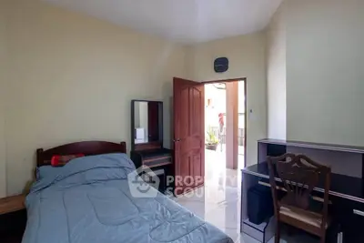 Cozy bedroom with single bed, desk, and open door to balcony, perfect for students or professionals.