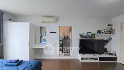 Modern living room with sleek TV setup and cozy decor in stylish apartment.