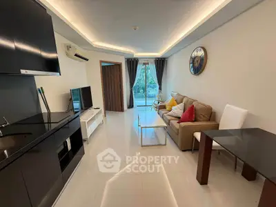 Modern living room with sleek furniture and large window offering garden view