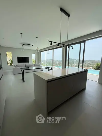 Luxurious open-plan living room with stunning panoramic views and modern kitchen island.