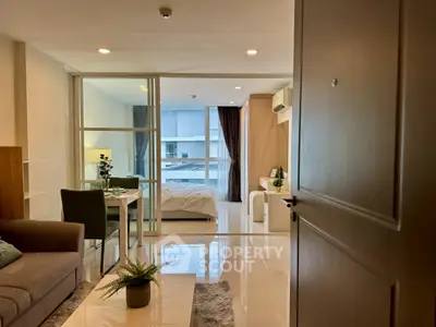 Modern open-plan apartment with stylish living room and cozy bedroom, featuring sleek furnishings and ample natural light.