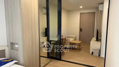 Modern apartment interior with wooden flooring and sliding glass doors, featuring a cozy living area and stylish decor.