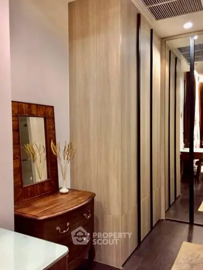 Elegant bedroom with mirrored wardrobe and stylish wooden furniture.