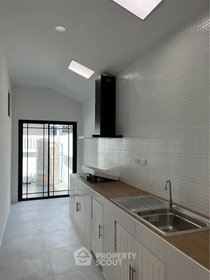 Modern kitchen with sleek design and natural light, featuring a gas stove and ample counter space.