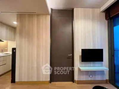 Modern interior with sleek kitchen and wall-mounted TV, featuring elegant wood paneling.