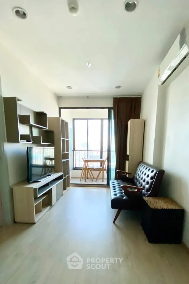 Modern living room with stylish furniture and balcony view in a bright apartment.