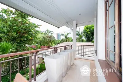 Spacious balcony with serene garden view, featuring elegant railings and ample space for outdoor relaxation in a lush, green setting.