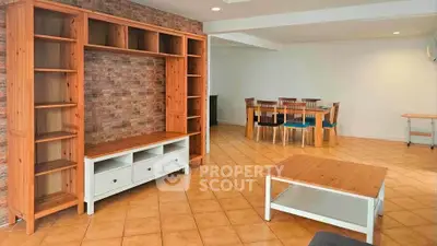 Spacious living room with wooden furniture and tiled flooring, perfect for family gatherings.