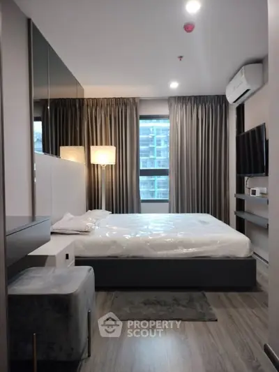 Modern bedroom with sleek design, featuring a large bed, stylish lighting, and floor-to-ceiling curtains.