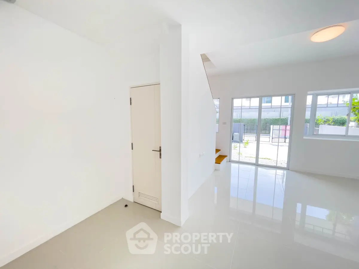 Bright and spacious modern living area with large windows and glossy floors