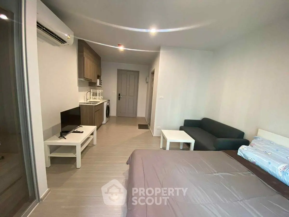 Modern studio apartment with compact kitchen and cozy living area, perfect for urban living.