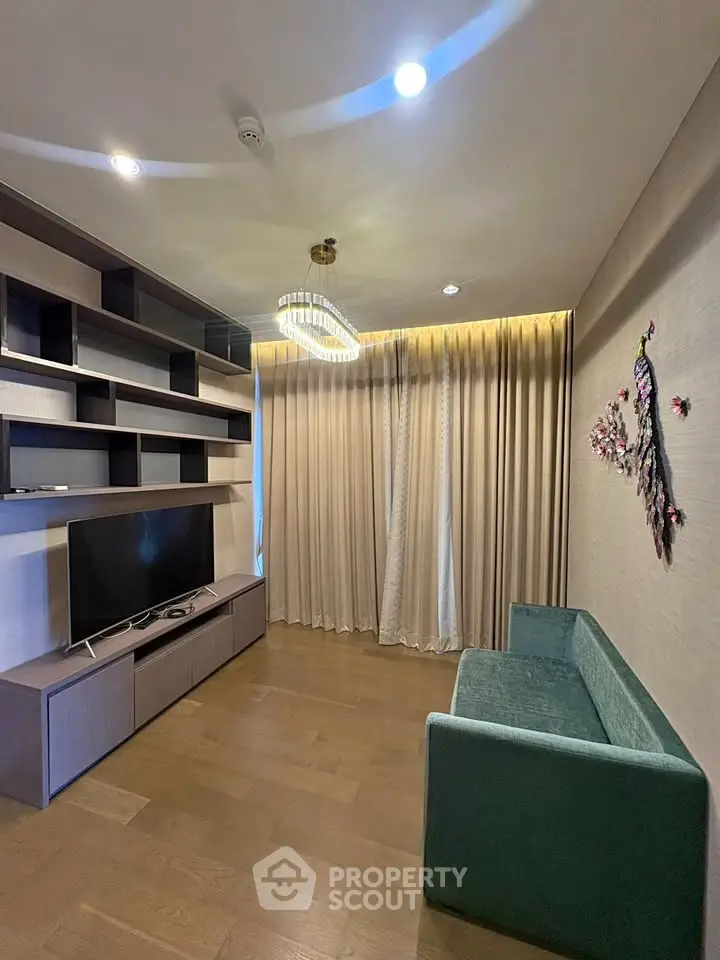 Modern living room with elegant shelving, TV, and stylish lighting in a cozy apartment.