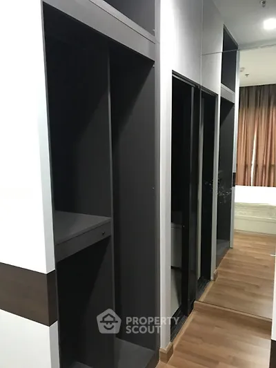 Spacious modern bedroom with sleek walk-in closet and wooden flooring