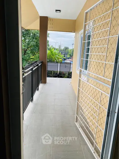 Spacious balcony with safety railing and scenic view, perfect for relaxation.