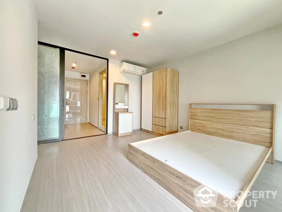 Spacious modern bedroom with wooden flooring and minimalist design